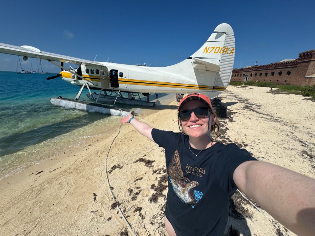 Dry Tortugas National Park: Our Half-Day, Seaplane Experience woman standing on the beach beside a seaplane at Dry Tortugas National Park