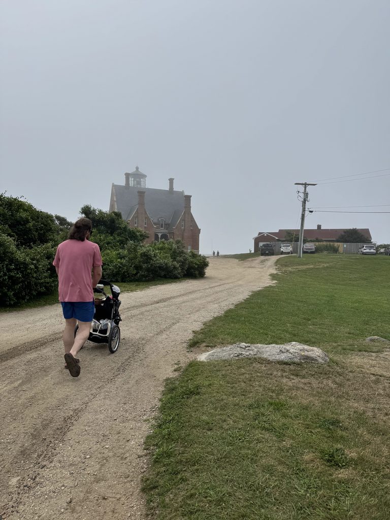 Rhode Island Family Vacation: Our 4-Day Narragansett Itinerary Dylan walking with a stroller toward Southeast Lighthouse on a foggy morning